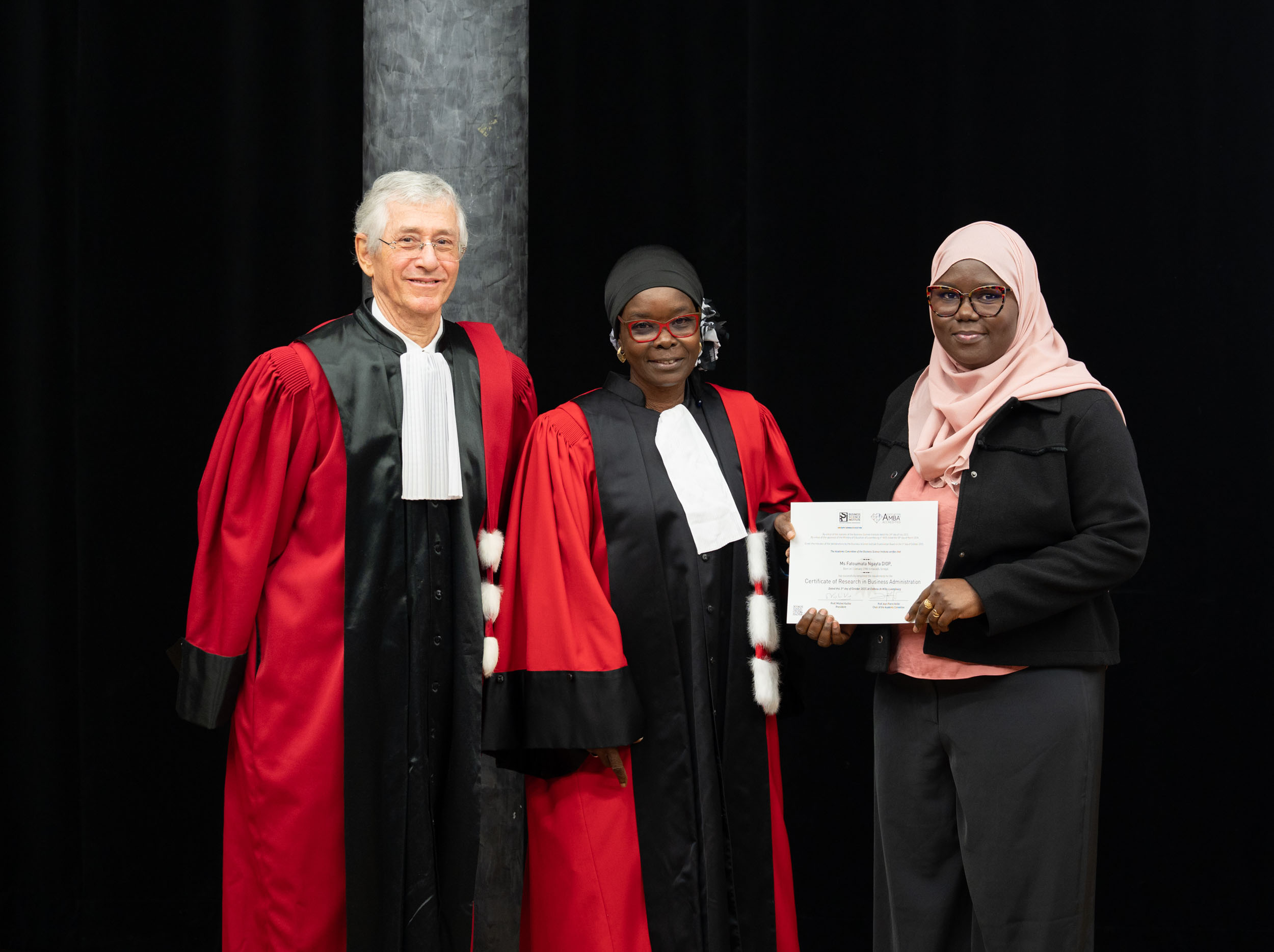 Des diplômés posent avec leur diplôme et le président du BSI